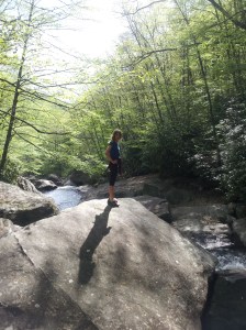 Karen on a boulder in the middle of a river, hiking with Megan in the Blue Ridge Mountains