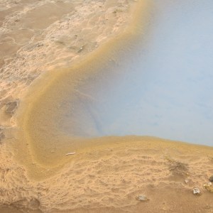 A pool of very hot water bubbling from the ground.