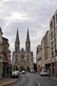 Église Saint-André with more modern buildings on either side of the street.