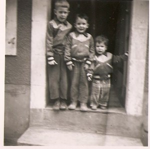 Jim and his brothers standing in the front door of their French house. Jim's in the middle.