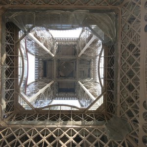 Looking up the center of the Eiffel Tower from underneath.