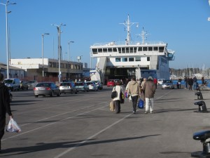 Boarding a ferry to visit a nearby island. Cars and pedestrians all come in and out together.