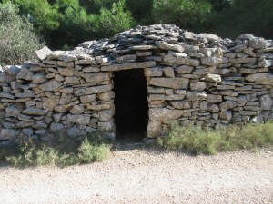 A small round stone hut built into a wall. The exact use of these ancient constructions is unknown. Today they are used by farmers for storage.